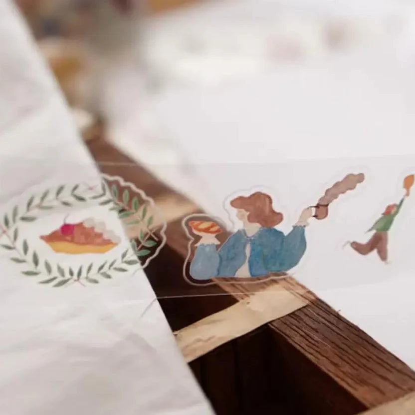 Pre-cut A Lovely Day PET Tape figures and a pie illustration arranged on a clean white surface