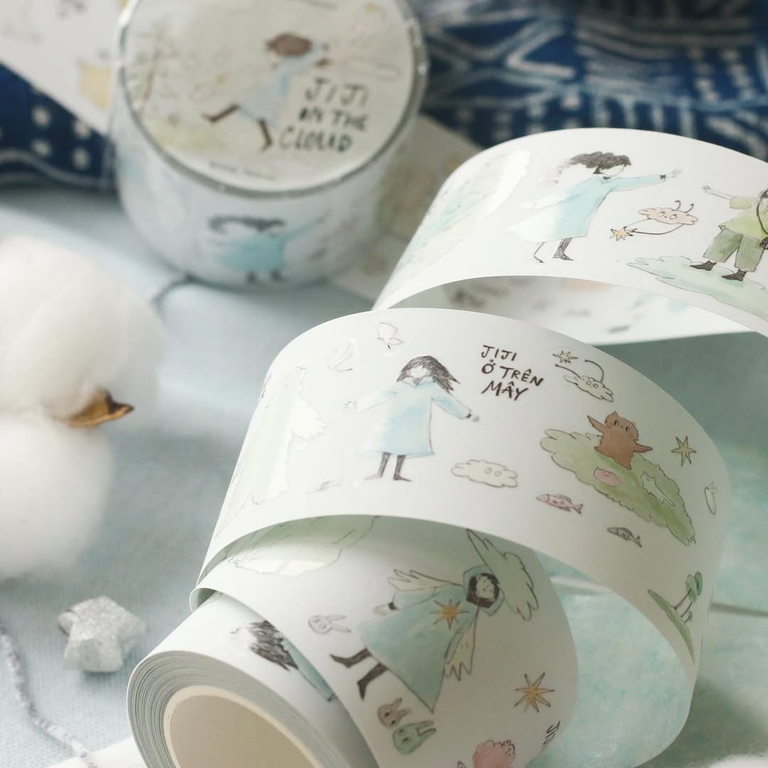 Rolls of Jiji On The Cloud PET Tape with soft cloud illustrations on a light background, top view