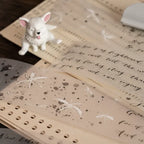 Small white dog figurine on an open book with decorative text and patterns
