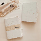 Two square blocks of soap with a 'love' band on a light background