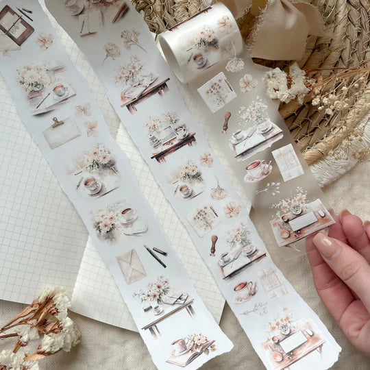 Rolls of Journaling PET Tape showing soft floral and tableware designs styled on a textured surface