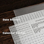 Calendar sticker sheets with text on a wooden surface