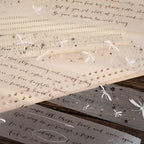 Decorative paper with text and embellishments on a wooden surface