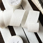 Rolls of decorative tape with printed designs on a wooden surface