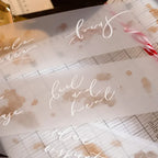 Translucent paper with printed text and floral designs on a wooden surface