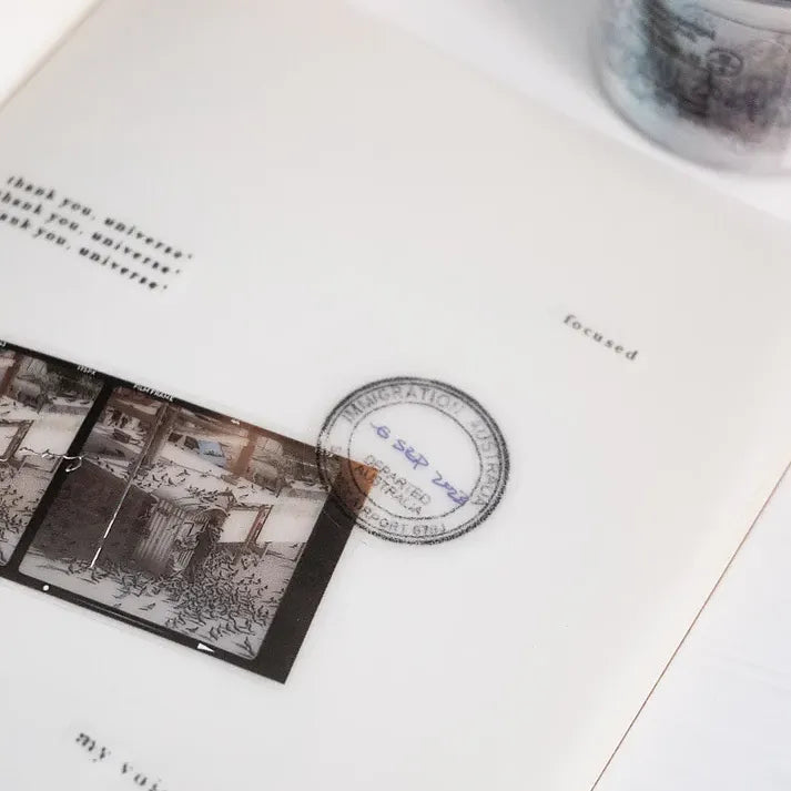 Close-up of a book page decorated with an Expired Visa Stamp PET Tape circular stamp motif