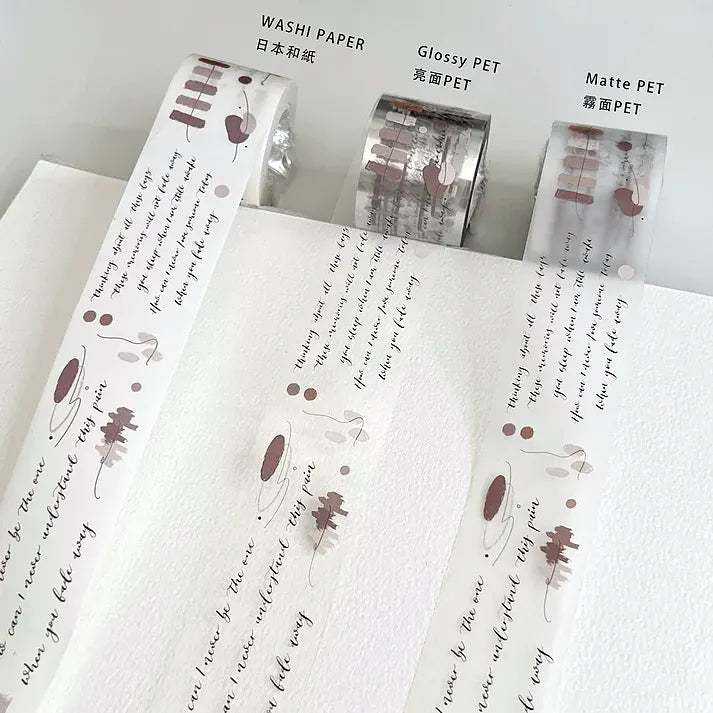 Fade Away PET Tape strips laid alongside washi paper samples with script text on a white surface