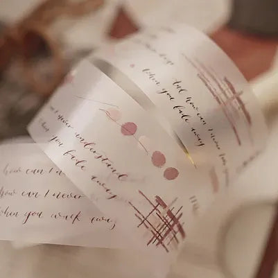 Roll of decorative tape with text and floral designs on a blurred background