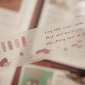 Decorative paper strip with text and designs on a blurred background