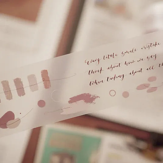 Fade Away PET Tape strip with handwritten text and artistic designs, close-up on a soft blurred backdrop