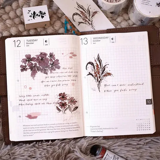 Open planner with floral designs and text on a textured surface