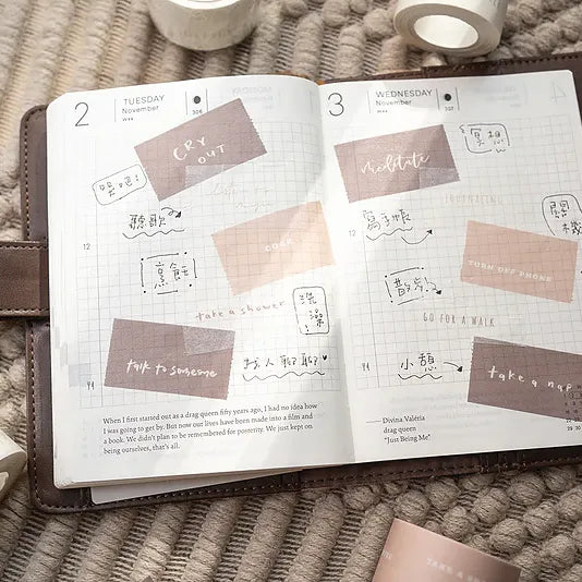 Open planner decorated with Healer Washi Tape affirmation stickers on a textured surface, top view
