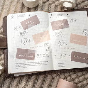 Open planner decorated with Healer Washi Tape affirmation stickers on a textured surface, top view