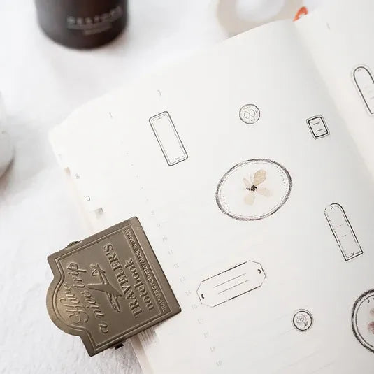 Bronze-colored travel-sized product packaging on a white surface with branding visible