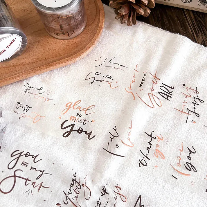 Sheet of Magic Time Rose Gold PET Tape stickers with assorted script phrases, overhead styled view