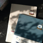 Two notebooks with kintsugi design on a dark surface