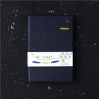Navy blue notebook with a white label featuring 'kintsugi' on a dark textured background