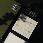 Notebook with a tea-themed sticker sheet on a dark background