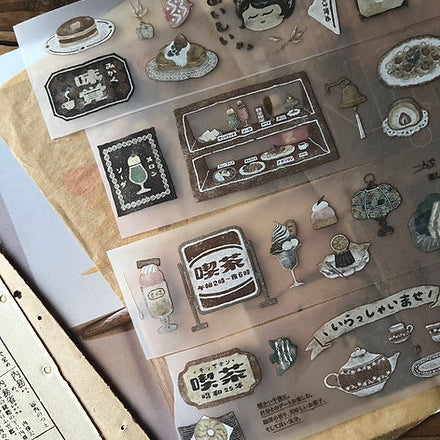 Collection of Kissaten Cafe PET Tape coffee-shop motifs laid out across a warm wooden surface