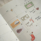 Calendar with decorative stickers and text on a white background