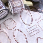 Sheet of gold foil shapes on a white surface with a blurred background