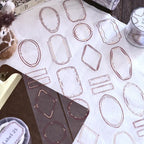 Set of geometric label templates on a white surface with a pen and container.
