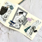Open book with illustrated pages featuring black and white drawings on a textured surface.