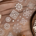 White lace patterns on a brown fabric background