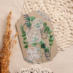 Decorative paper tag with greenery and lace design on a textured surface