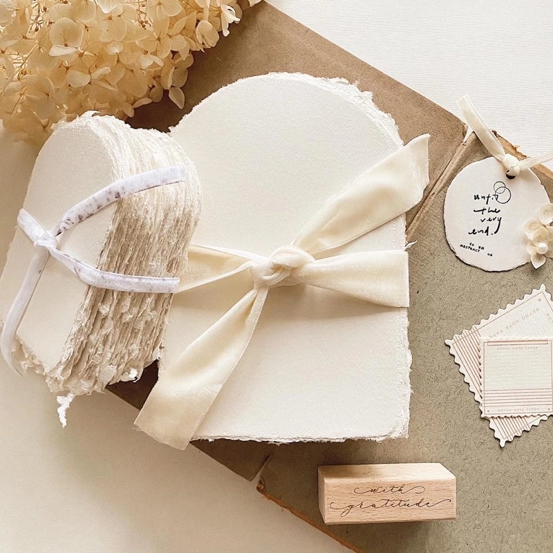White gift box with a bow, surrounded by decorative elements on a neutral background