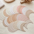 Set of beige and pink circular fabric swatches on a light wooden surface.