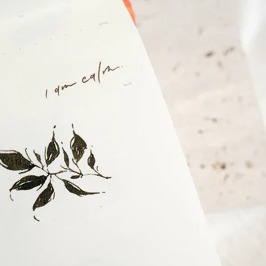 Black leaf design and lettering from the Leaves PET Tape applied on a white surface, close-up view
