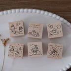 Set of six wooden stamps with illustrations on a white plate.