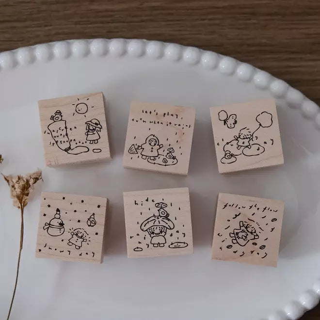 Full set of six Let's Play weather-themed wooden stamps arranged on a white plate