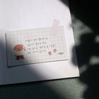 Notebook with grid paper featuring cartoon characters and text on a textured surface.