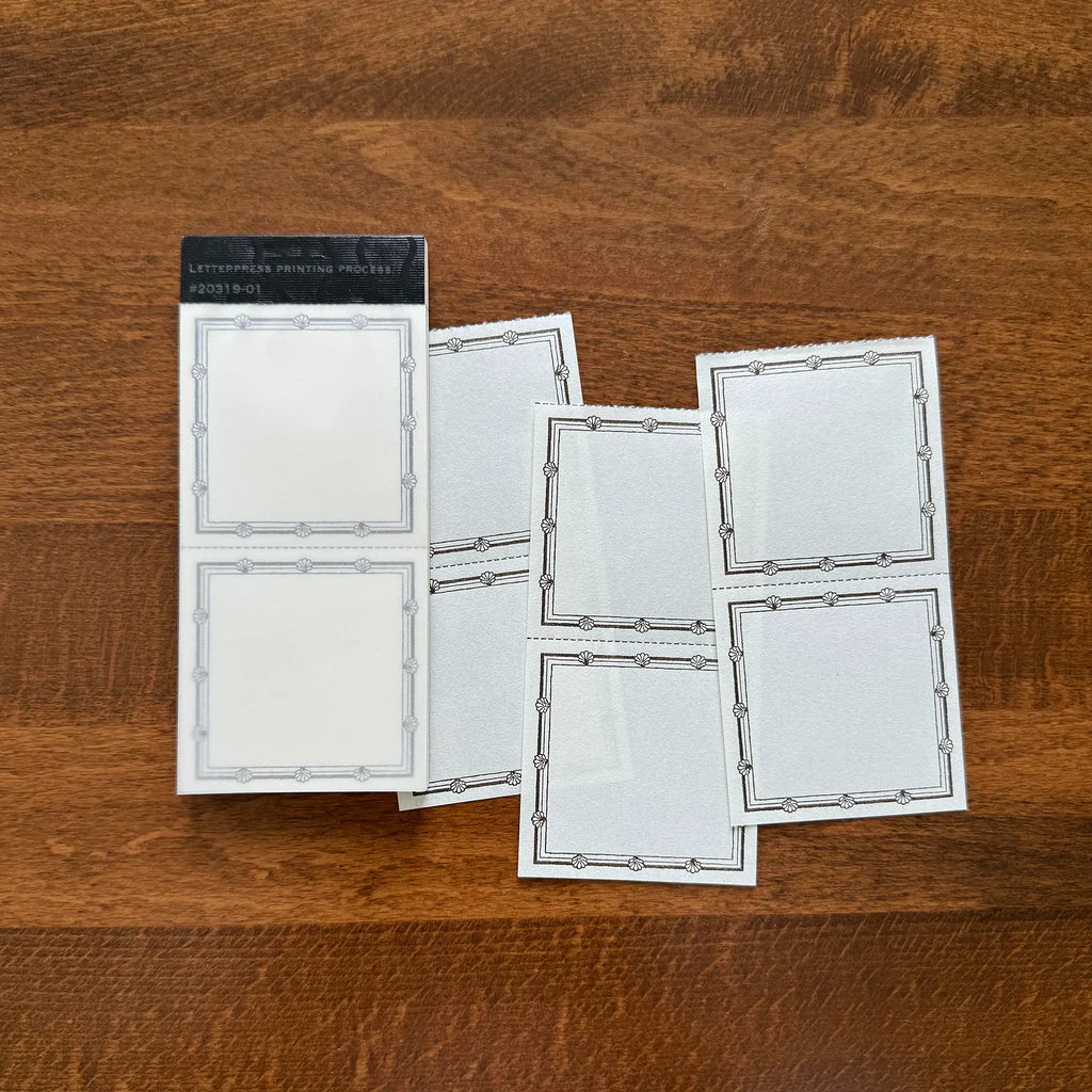 Letterpress Label Memo Pad by Classiky white perforated label sheets with black borders on wood