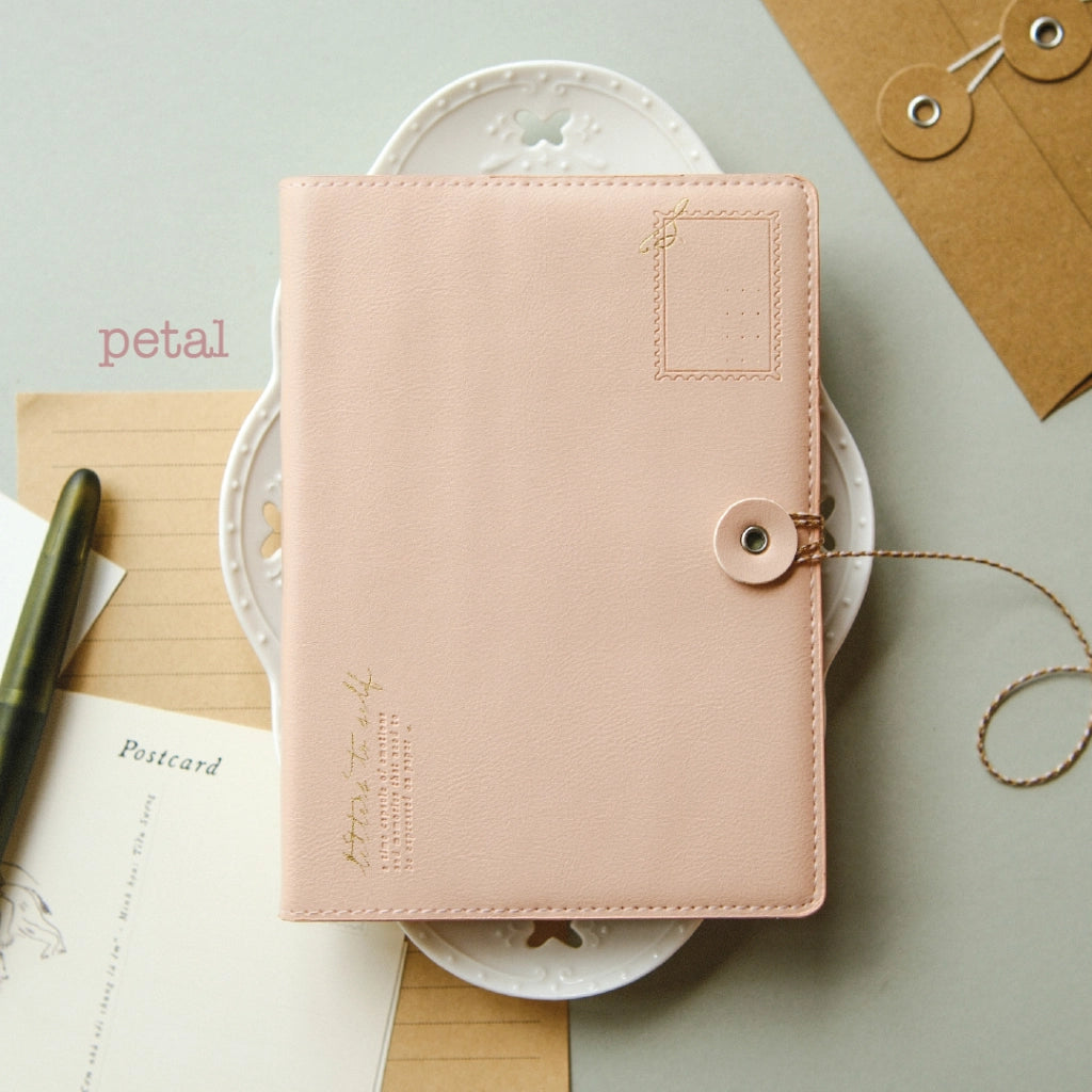 Pink notebook with decorative elements on a light green background