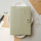 Green notebook with decorative elements on a light background