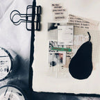 Black eye mask on a white surface with text and stationery items