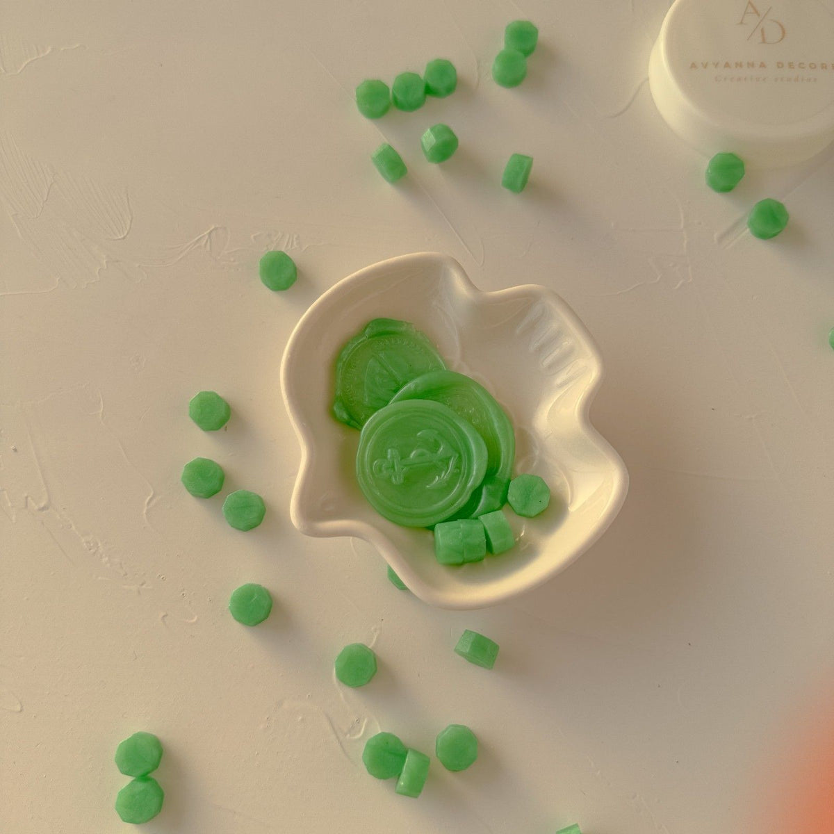 Lime Life Wax Beads gathered in a white leaf-shaped dish on a warm beige surface, top-down styled view
