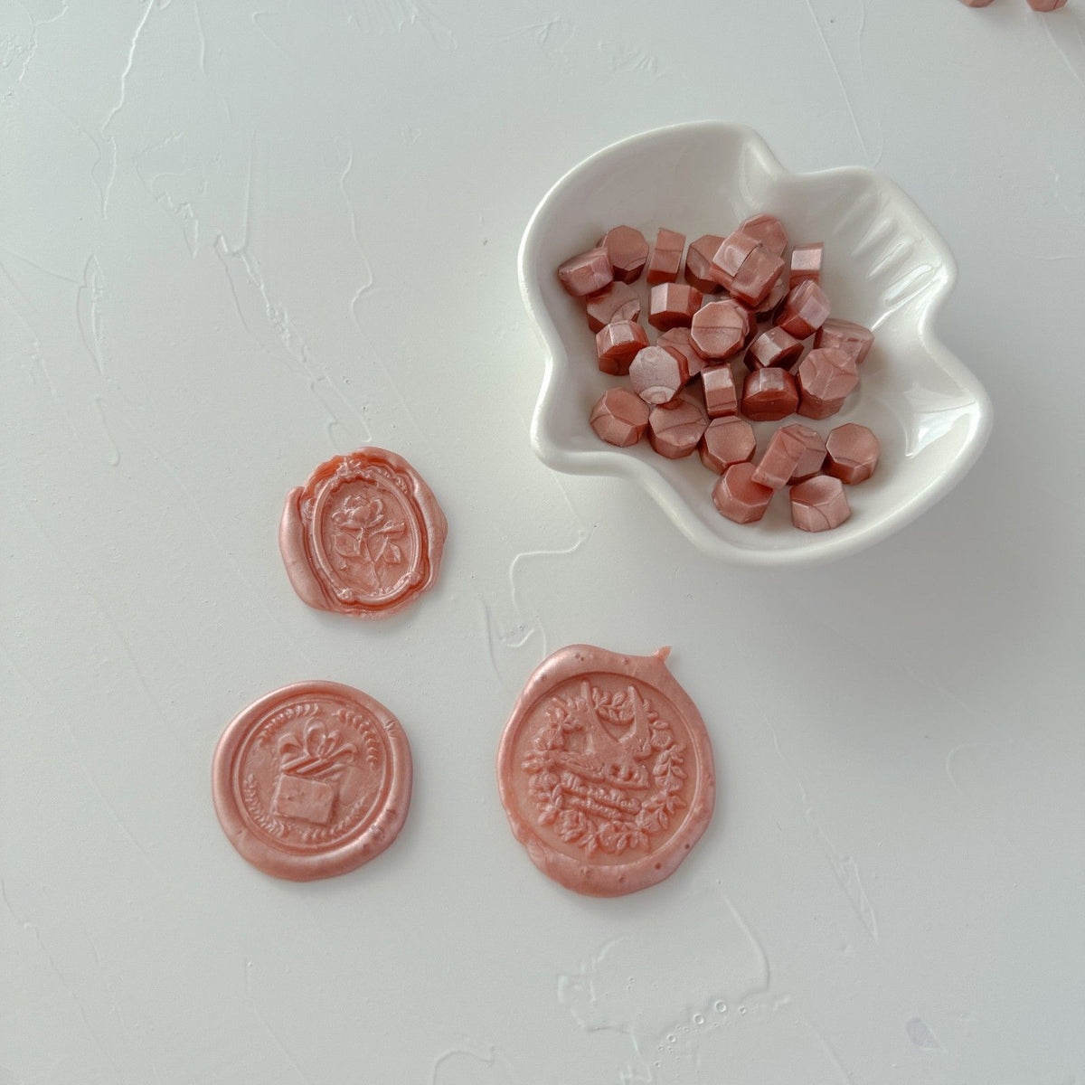 Lingering Brew Wax Beads with stamped wax seals beside a small white dish, flat lay on a clean white surface