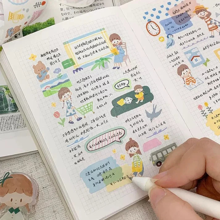Notebook decorated with Little Thing Washi Tape illustrations with a hand holding a pen