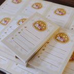 Stack of small notebooks with decorative covers on a wooden surface