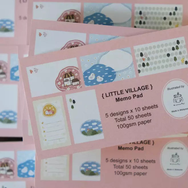 Pink Little Village Memo Pad with illustrated designs on a matching pink background