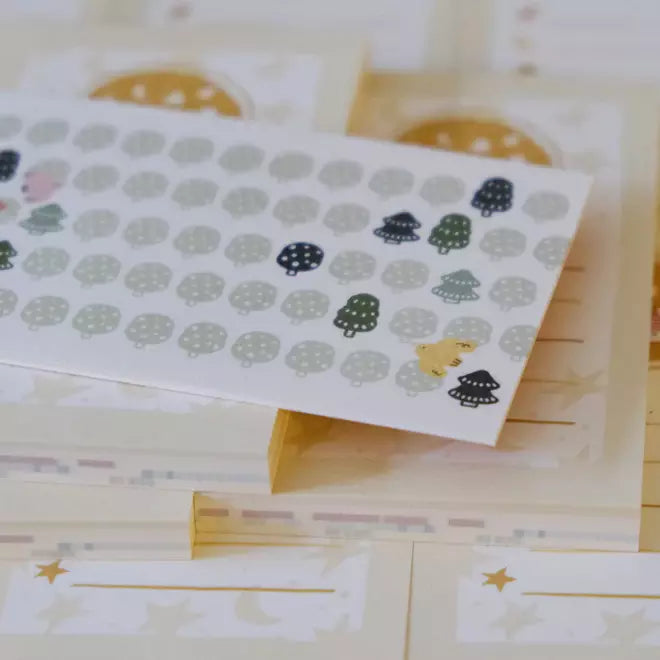 Set of small envelopes with cute illustrations on a wooden surface