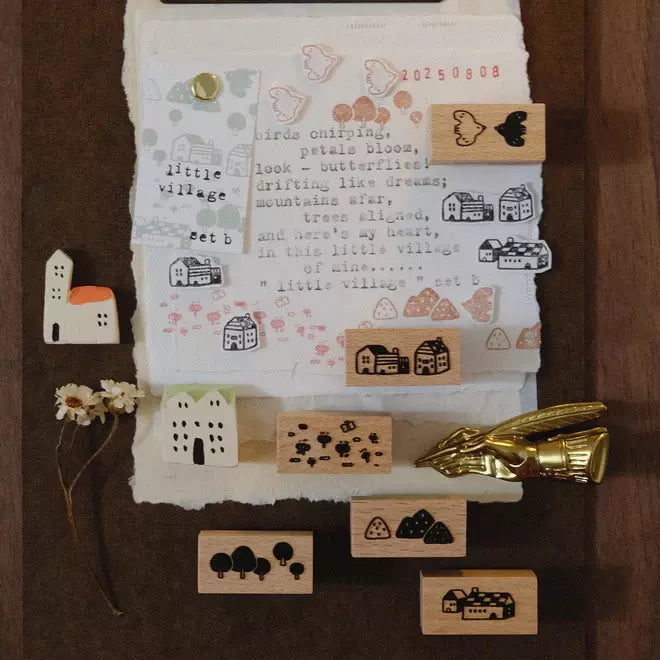 Little Village stamps with small buildings and nature designs on a paper sheet with text