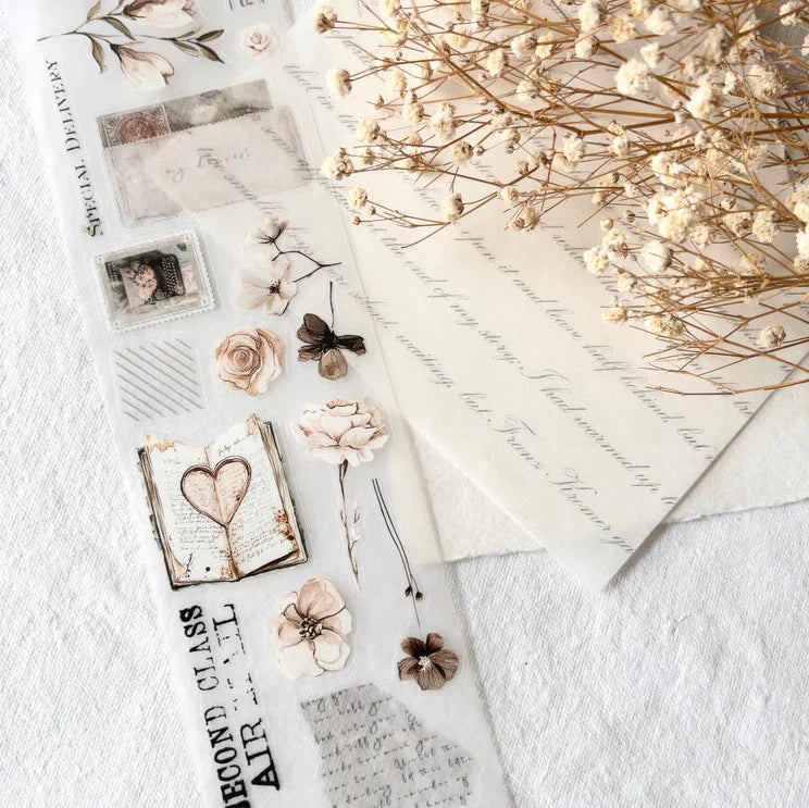 Flat lay of Love Letters PET Tape styled with flowers, cards and a letter on a textured surface