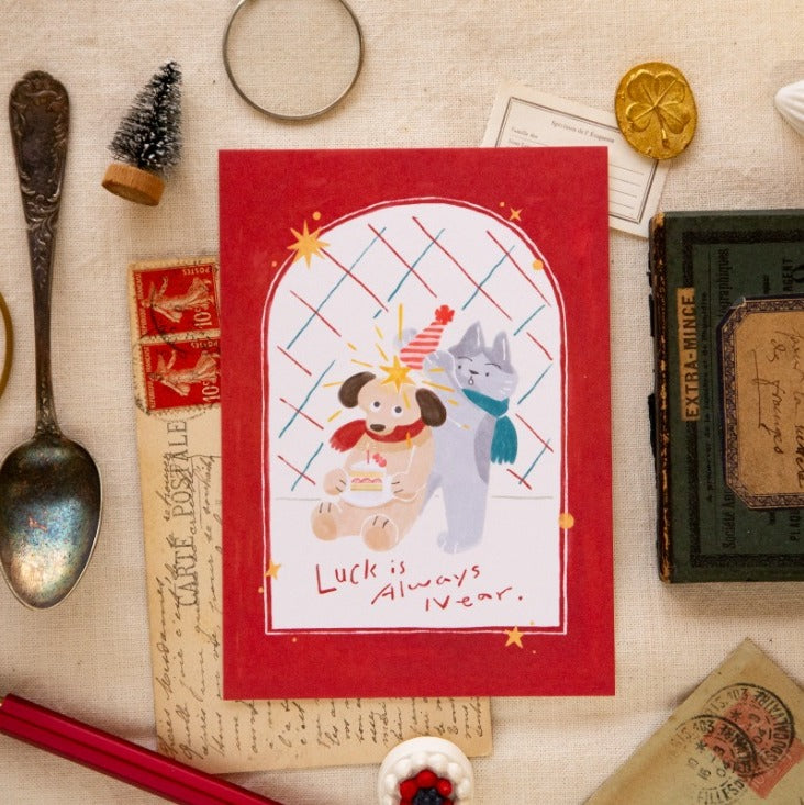 Card with cartoon dog and cat on a red background, surrounded by vintage items.