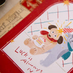 Illustration of a dog and a cat with a star, featuring the text 'Luck is Always IV', on a red border.