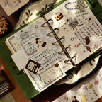 Open notebook with decorative pages and illustrations on a wooden surface